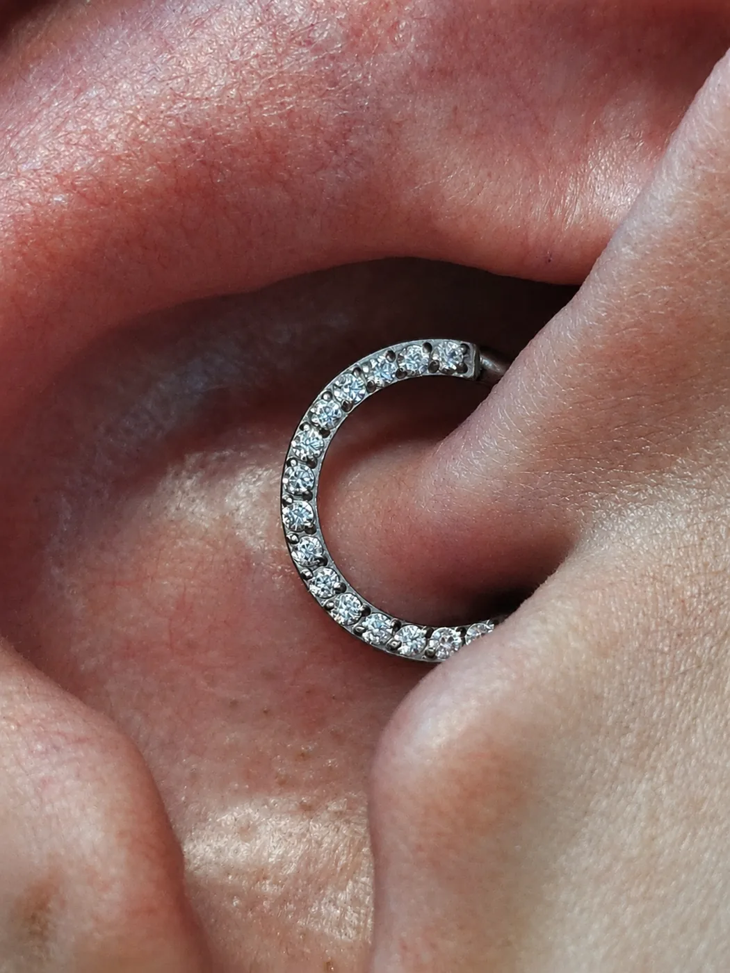 Piercing daith com argola totalmente cravejada, aplicado na Memphis