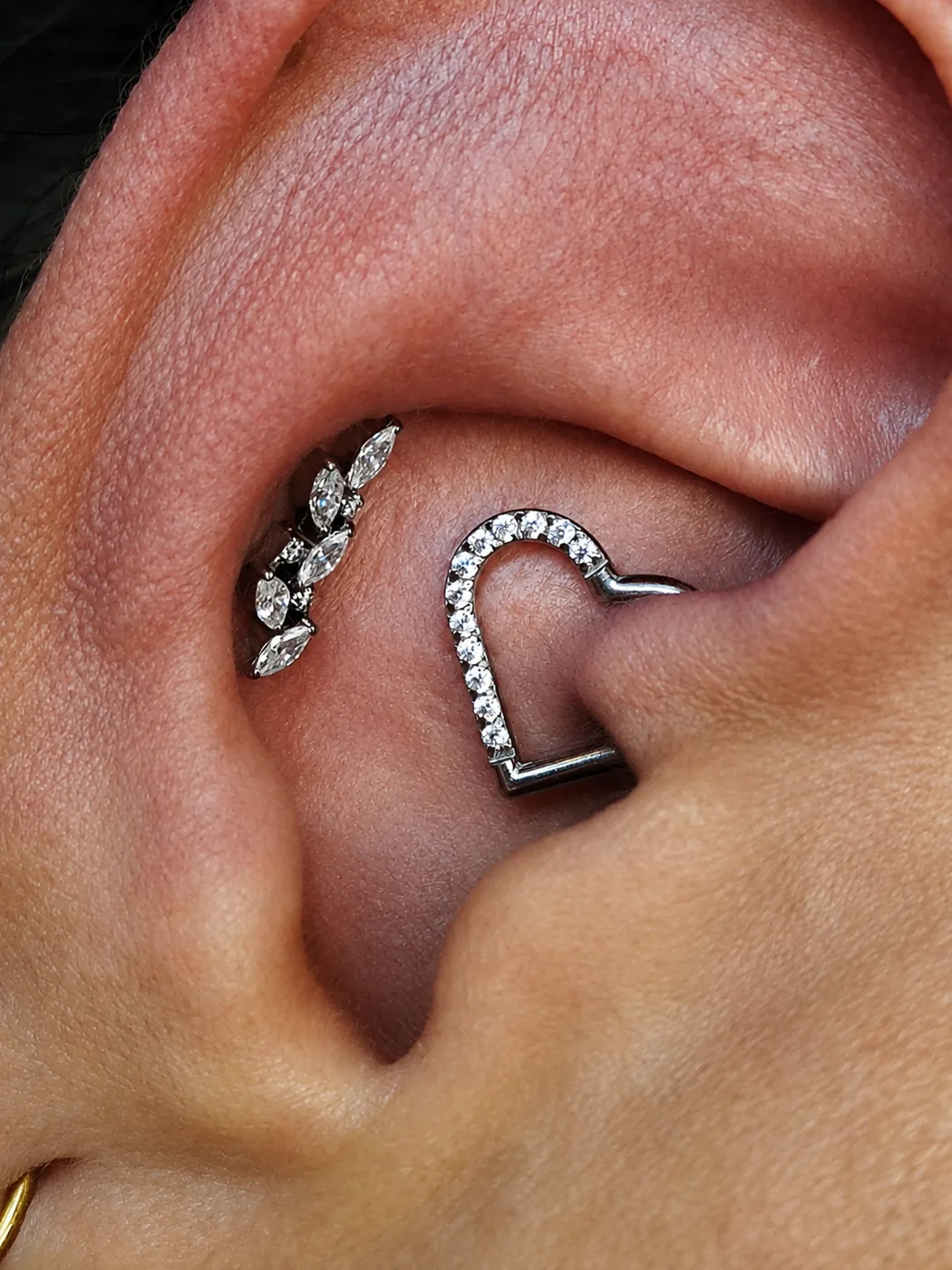 Piercing rook com joia cravejada e joia de folhas na orelha