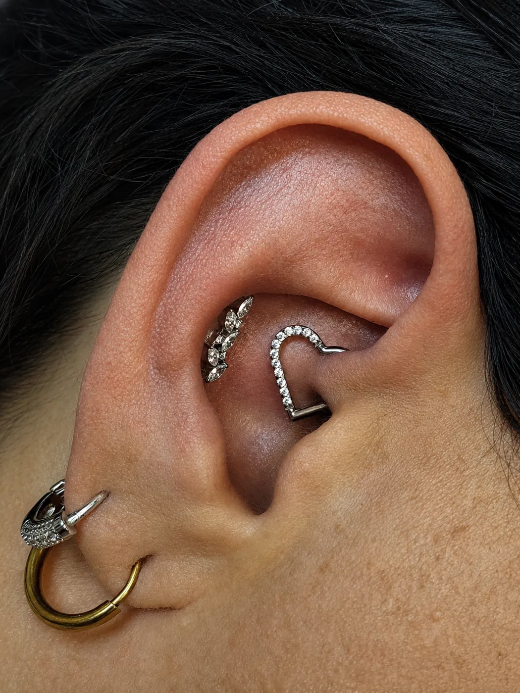 Rook e daith com joias cravejadas e argola dourada larga no lóbulo